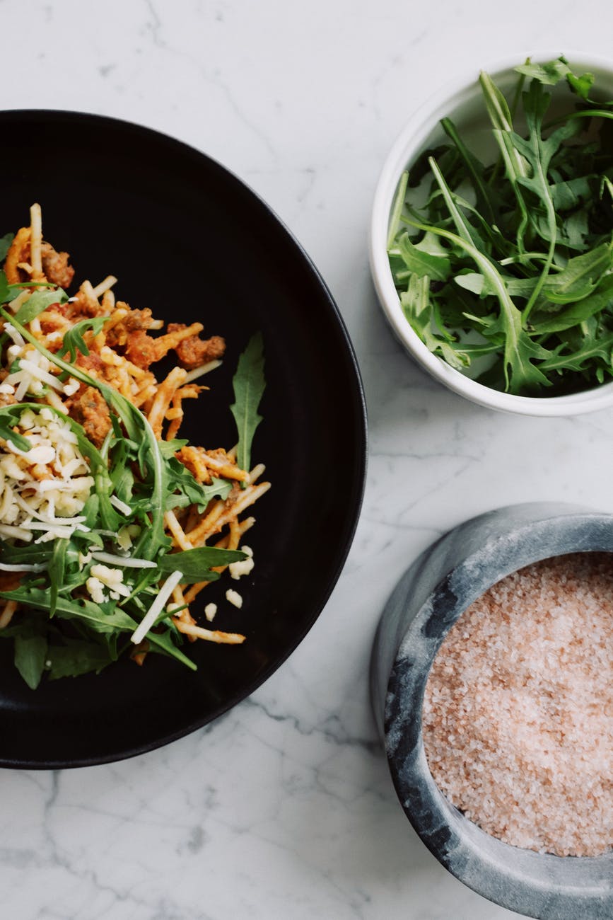 delicious pasta bolognese with arugula and pink salt